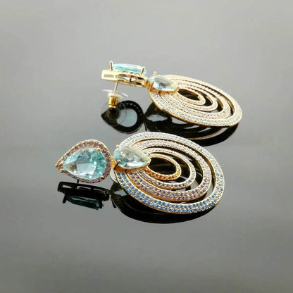 Rose gold colored earrings with turquoise colored zirconias
