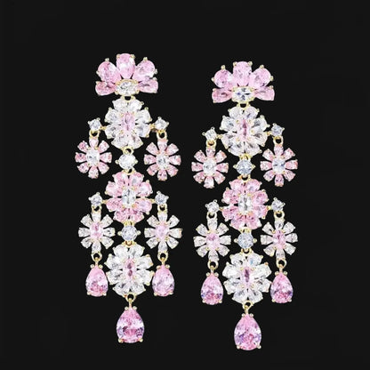 Gold-colored long flower-shaped earrings with pink zirconias